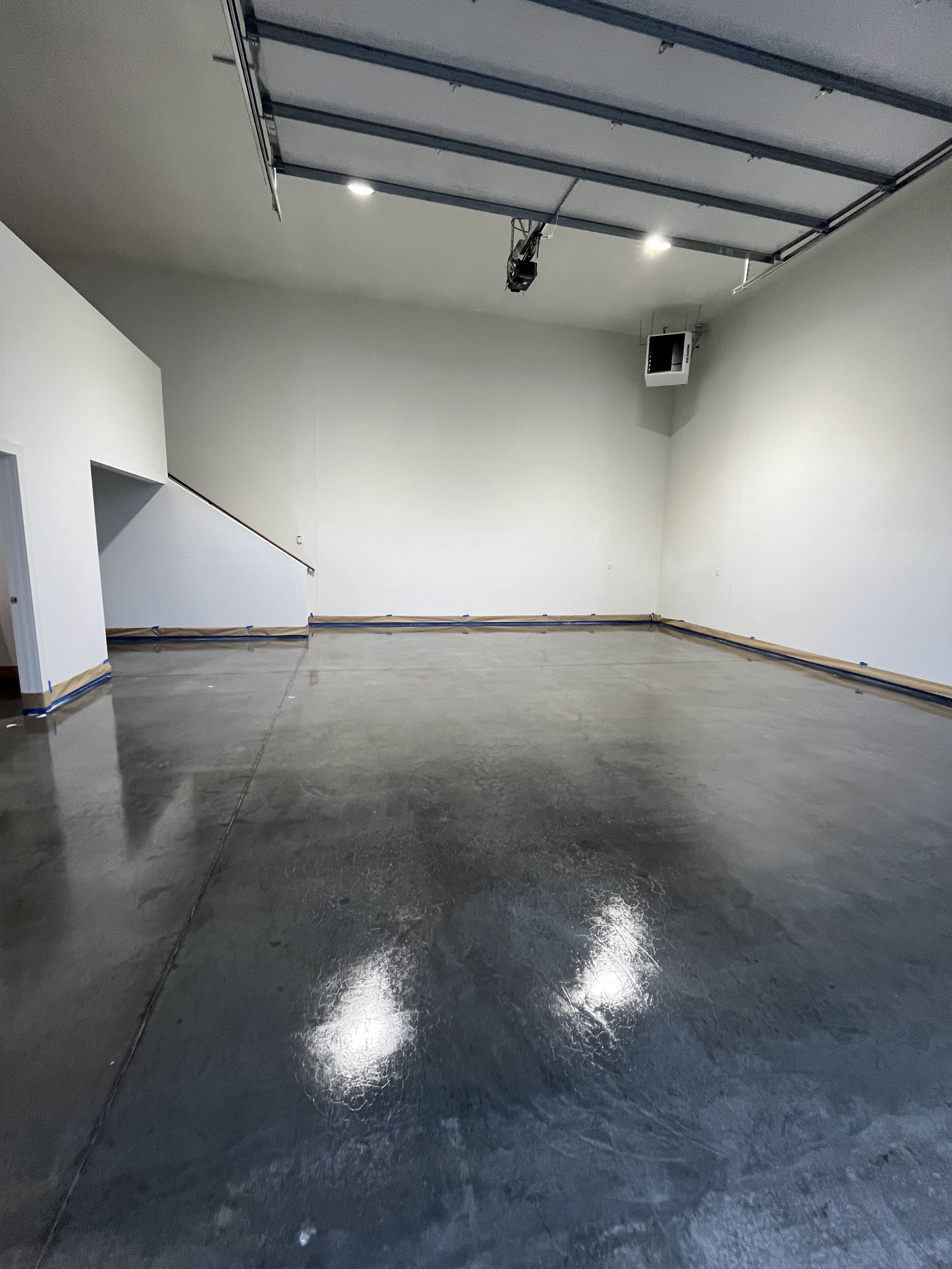 Inside a unit: an open bay door looking out to the gravel yard, concrete slab, and a door through to the private office.